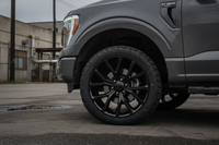 Dark gray Ford F-150 truck with black multi-spoke wheels and all-terrain tires